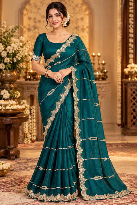 Soft Shiny Georgette Saree with a beautiful flowy drape, elegant stonework lines and a rich scalloped stone border. Attached blouse piece included; model blouse is for reference only. Slight variation in colour and design is possible.
