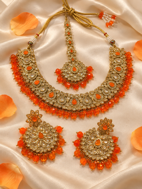 Elegant polki Necklace Set featuring beautiful Kundan stones, pearl detailing and bead drops. Comes with matching earrings and maang tikka. Slight variation in colour and design may be possible.