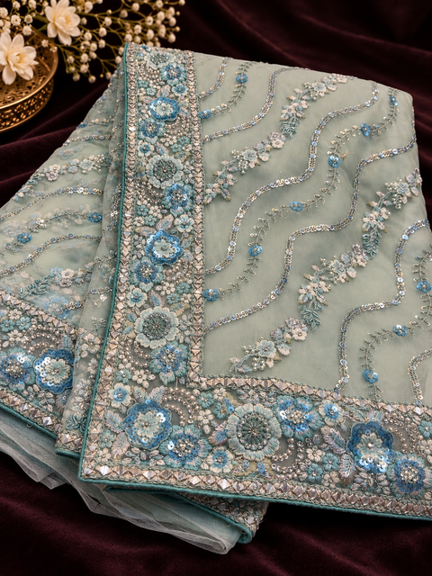 Heavy Embroidered Net Saree Beautiful net saree with all-over floral embroidery, sequin work & a rich heavy border.Blouse shown is for reference only; actual blouse piece is attached with the saree. Slight variation in colour/design possible.