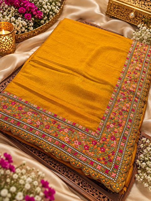 Soft Silk Blend Saree featuring a rich multicolour floral embroidered border with elegant scalloped detailing. Attached blouse piece included; model blouse is for reference only. Slight variation in colour and design is possible.
