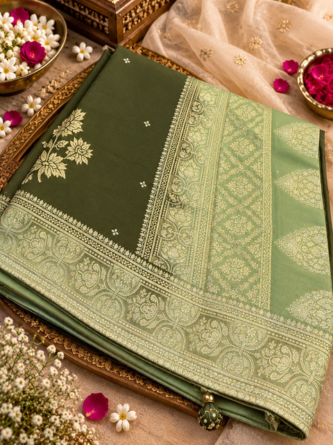 Dola Silk Saree with elegant all-over floral zari weaving and a rich contrasting woven border with detailed pallu. Soft, graceful drape with a luxurious festive look. Contrast blouse piece included.Slight variation in colour and design is possible.