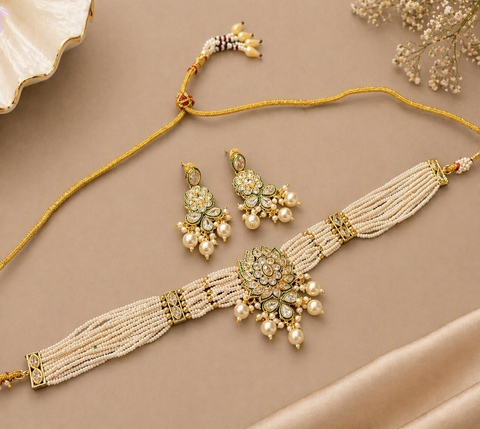 Elegant pearl choker set featuring intricate gold detailing and a statement original kundan-style centerpiece, paired with matching earrings for a timeless look.Perfect blend of tradition and sophistication
