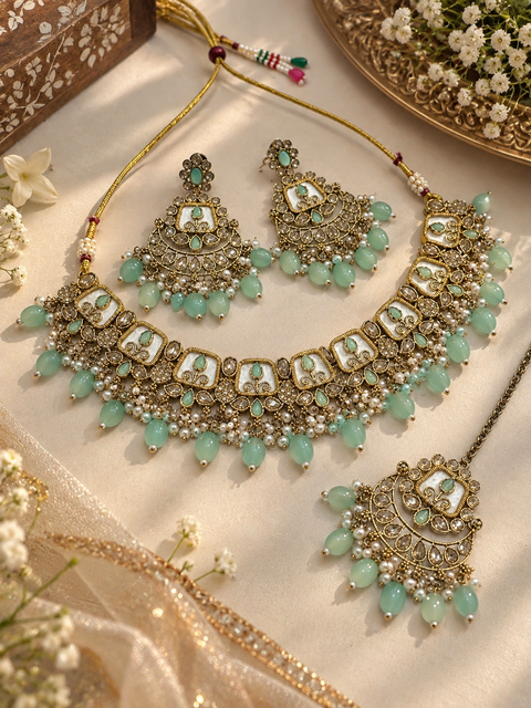 Beautiful polki stones with pearls and colorful stones necklace & earrings with Tikka. Slight variations in colour and design are possible