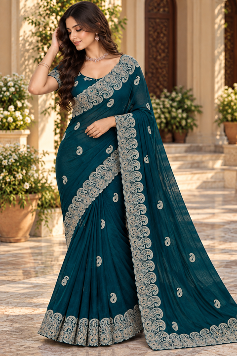 Teal color Soft silk blend saree with a beautiful fall, featuring intricate paisley embroidery and all-over buti work. Attached blouse piece included; model blouse is for reference only. Slight variation in colour and design is possible.