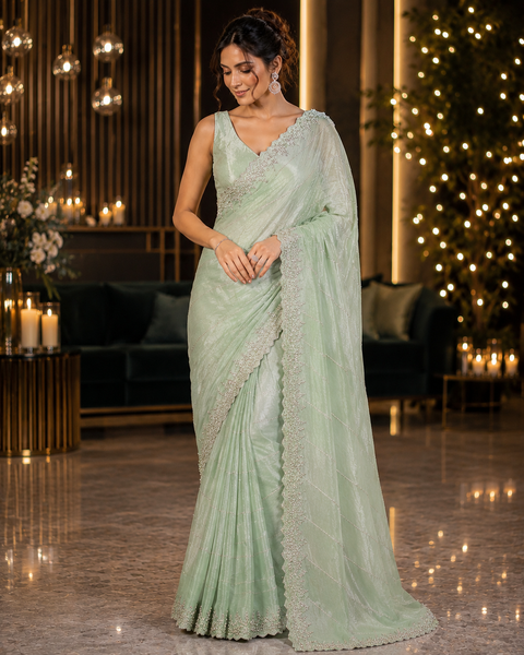 Elegant Jimmy Choo Saree featuring intricate handwork detailing and a beautifully embellished border. Comes with an attached matching blouse piece, blouse worn by the model is for reference purposes only(slight variation in color and design is possible)