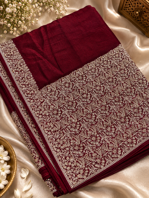 Soft-flowing fancy silk georgette saree with elegant embroidered borders, fine stone work and a heavy detailed pallu. Includes an attached embroidered blouse piece; model blouse is for reference only. Slight variation in colour/design possible.
