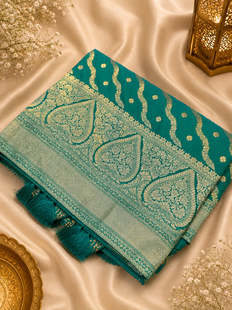 Premium Banarasi Silk Saree featuring elegant zari weaving throughout; saree comes with an attached blouse piece. Model blouse is for reference only. Slight variation in colour and design may occur