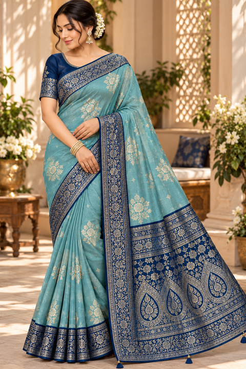 Dola Silk Saree with elegant all-over floral zari weaving and a rich contrasting woven border with detailed pallu. Soft, graceful drape with a luxurious festive look. Contrast blouse piece included.Slight variation in colour and design is possible.