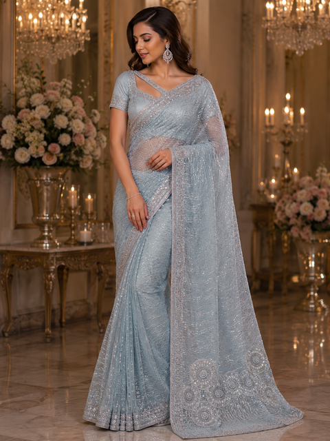 Heavy work designer Saree with netting base fabric and stones work design all over with heavy embroidery .The Blouse Worn By The Model Is For Reference Purposes Only. The Actual Blouse Piece Comes Attached With Saree(Slight Variations Are Possible)