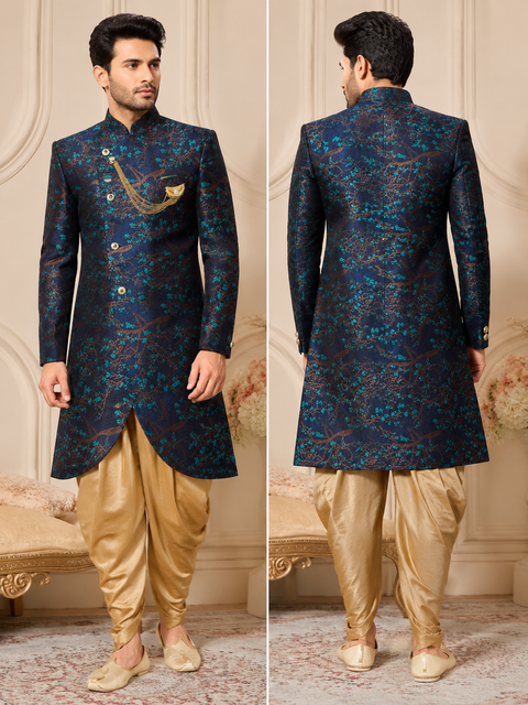 Premium navy blue jacquard sherwani with elegant floral woven detailing, paired with a classic gold dhoti for a sophisticated festive and wedding look. Slight variation in color and design may occur.
