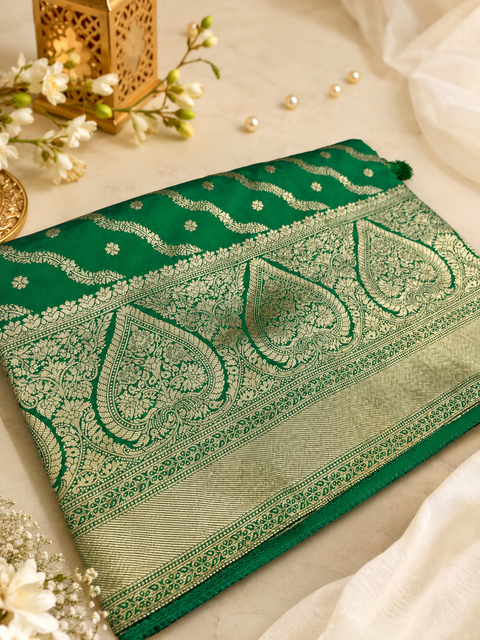 Premium Banarasi Silk Saree featuring elegant zari weaving throughout; saree comes with an attached blouse piece. Model blouse is for reference only. Slight variation in colour and design may occur