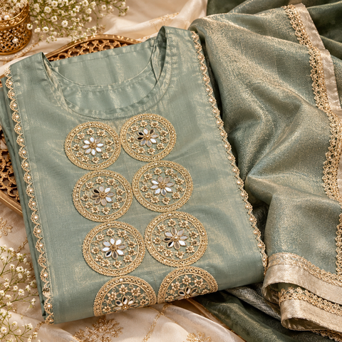 Sage Green color fendy silk, luxurious fabric with a subtle shine. Features stunning mirror work on the neckline, elegant embroidered borders, matching pants and a graceful dupatta. Slight variations in colour and design are possible.