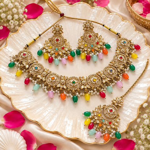 Beautiful polki stones with pearls and colorful stones necklace & earrings with Tikka. Slight variations in colour and design are possible