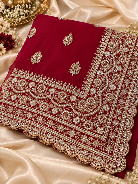 Georgette Saree featuring intricate embroidery, elegant stonework and a rich scalloped border with all-over motif detailing. Attached blouse piece included; model blouse is for reference only. Slight variation in colour and design is possible.