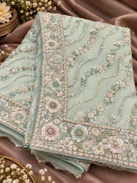 Heavy Embroidered Net Saree Beautiful net saree with all-over floral embroidery, sequin work & a rich heavy border.Blouse shown is for reference only; actual blouse piece is attached with the saree. Slight variation in colour/design possible.