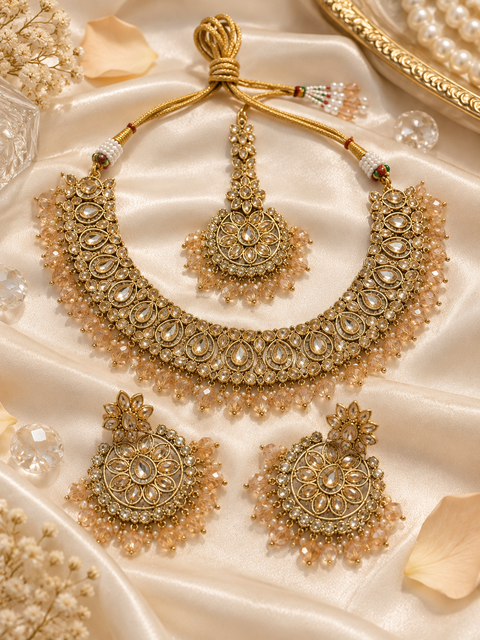 Elegant polki Necklace Set featuring beautiful Kundan stones, pearl detailing and bead drops. Comes with matching earrings and maang tikka. Slight variation in colour and design may be possible.