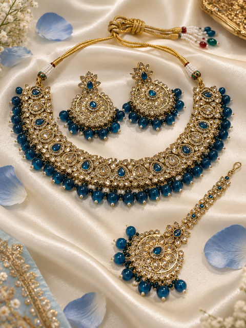 Elegant polki Necklace Set featuring beautiful Kundan stones, pearl detailing and bead drops. Comes with matching earrings and maang tikka. Slight variation in colour and design may be possible.
