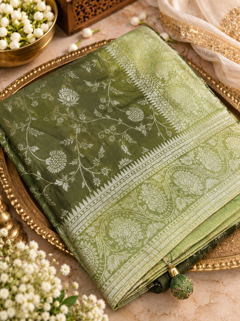 Dola Silk Saree with elegant all-over floral zari weaving and a rich contrasting woven border with detailed pallu.  Model blouse for reference only . Contrast blouse piece included.Slight variation in colour and design is possible.