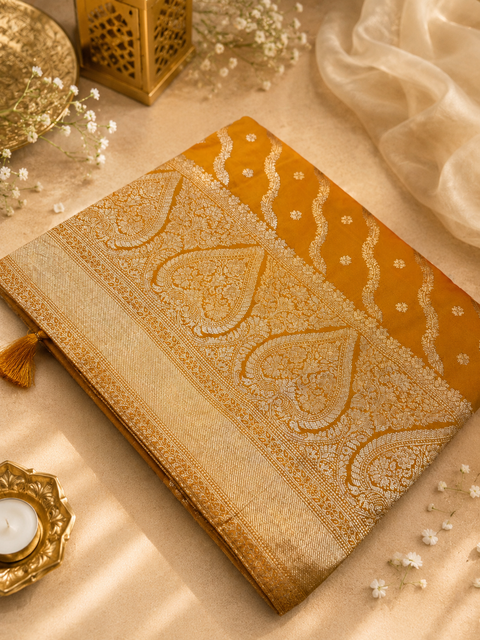 Premium Banarasi Silk Saree featuring elegant zari weaving throughout; saree comes with an attached blouse piece. Model blouse is for reference only. Slight variation in colour and design may occur