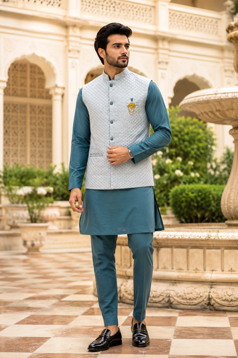 Premium teal kurta set with a textured silver jacket, crafted for a refined festive and wedding-ready look. Slight variation in color and design may occur.