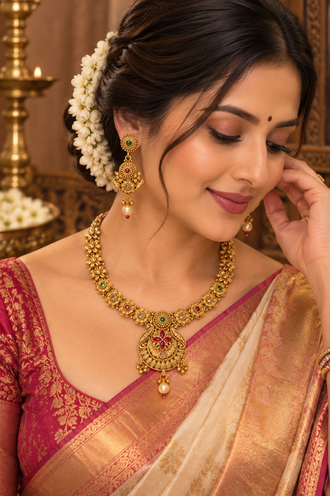 Elegant South Indian temple-style necklace set with intricate floral detailing, red and green stones, and pearl drops. Comes with matching earrings.(slight variation in color & design may occur)
