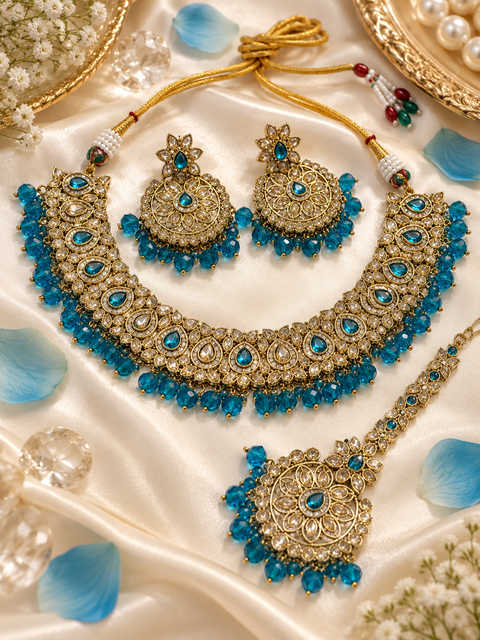 Elegant polki Necklace Set featuring beautiful Kundan stones, pearl detailing and bead drops. Comes with matching earrings and maang tikka. Slight variation in colour and design may be possible.