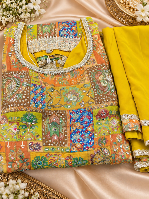 Silk-blend patchwork kameez with mirror & stone work, paired with a flowy circular palazzo and plain georgette dupatta with golden border. Slight variation in colour/design possible