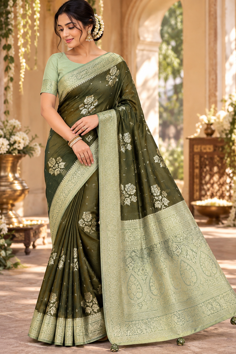 Dola Silk Saree with elegant all-over floral zari weaving and a rich contrasting woven border with detailed pallu. Soft, graceful drape with a luxurious festive look. Contrast blouse piece included.Slight variation in colour and design is possible.