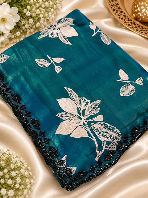 Fendi Silk Saree – Elegant floral print with beautiful black stone handwork border all around. Soft, stylish, two toned shiny. Matching blouse piece attached; model blouse is for reference only. Slight variation in colour/design is possible.