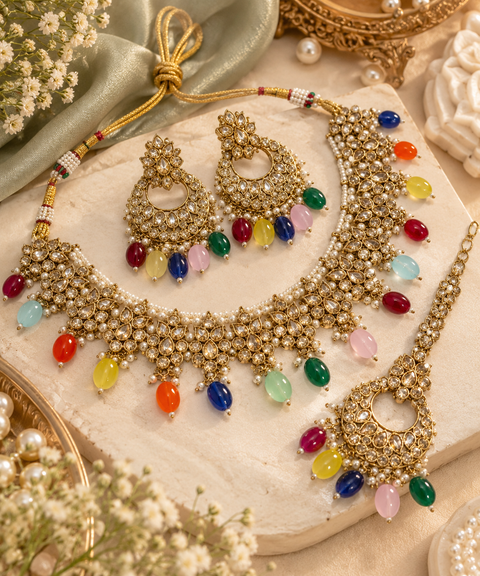 Beautiful polki stones with pearls and colorful stones necklace & earrings with Tikka. Slight variations in colour and design are possible.