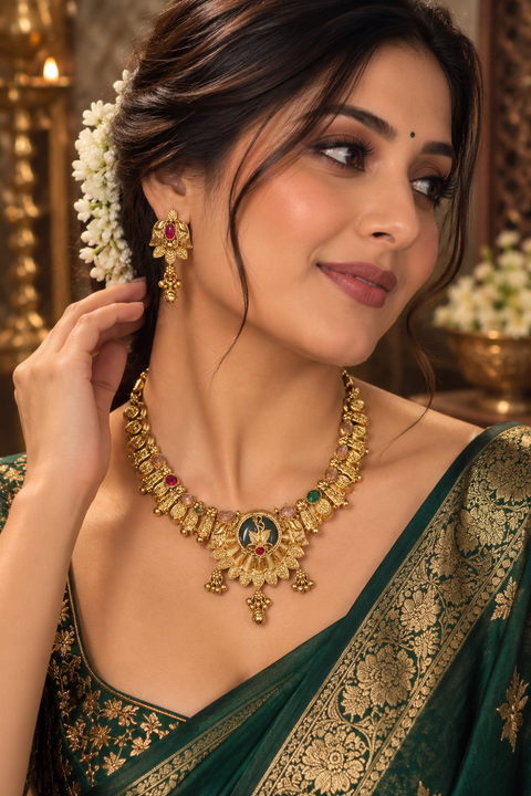 Elegant temple-style gold necklace set with intricate detailing, multicolour stones and pearl accents. Comes with matching jhumka earrings.(slight variation in color & design may occur)