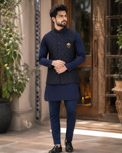 Elegant dark navy kurta set with a premium textured jacket, detailed gold accents, and a refined festive look. Slight variation in color and design may occur.
