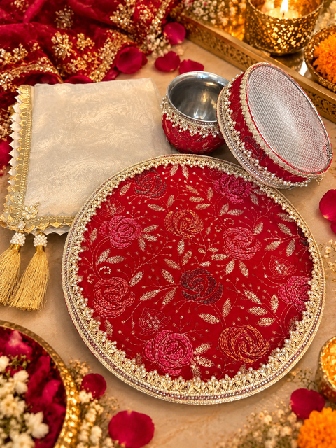 Elegant Karwa Chauth Thali Set with red floral embroidery, pearl detailing and matching thali, channi, kalash and cover cloth. Slight variation in colour and design is possible.