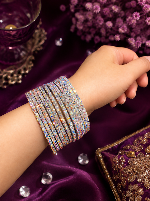 Beautiful silver-tone bangles embellished with shimmering rainbow AB crystal stones for an elegant, eye-catching sparkle.(slight variation in color and design is possible) one dozen bangles per set (price per set)