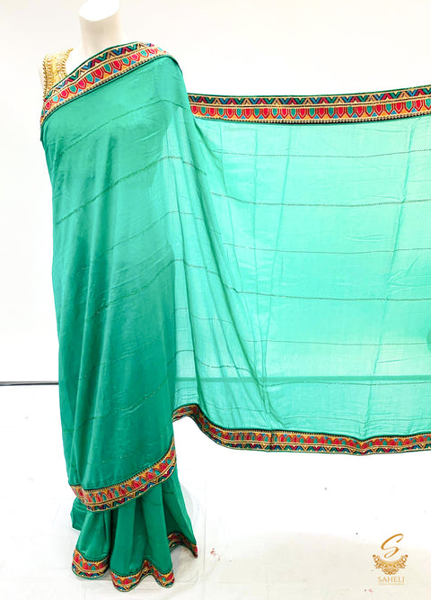green colour soft crape silk based embroidered broder with stone work saree