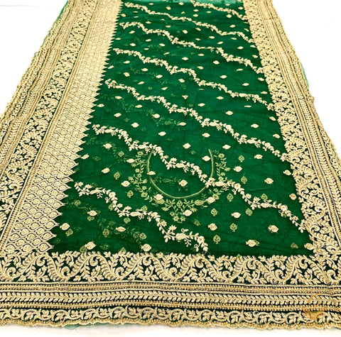 Dark bottle green colour netting based heavy embroidery jall all over with beautiful stone work heavy border and embroidered work design on blouse